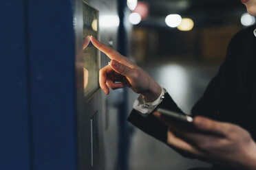 Geschäftsfrau an einem Fahrkartenautomaten, Mailand, Italien - ISF06111