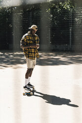 Cooler junger Mann im Skatepark, der sein Smartphone benutzt - UUF13829