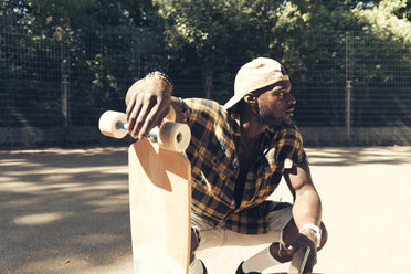 Cooler junger Mann im Skatepark, der sein Smartphone benutzt - UUF13835