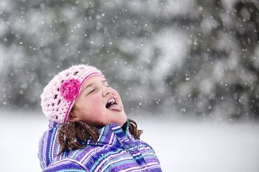 Mädchen fängt Schneeflocke auf ihrer Zunge - ISF06115