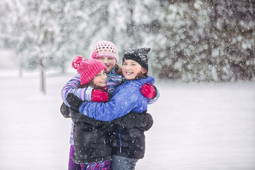 Friends embracing in snowfall - ISF06119