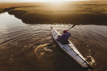 Rückansicht einer Kajak fahrenden Frau auf einem Fluss bei Sonnenuntergang, Morro Bay, Kalifornien, USA - ISF06186