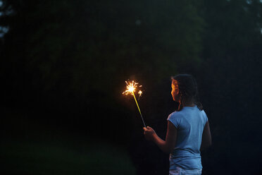 Mädchen betrachtet Wunderkerze im Garten bei Nacht am Unabhängigkeitstag, USA - ISF06198