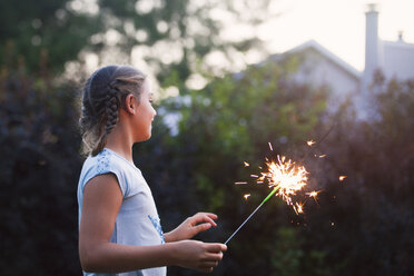 Mädchen hält Wunderkerze im Garten in der Abenddämmerung am Unabhängigkeitstag, USA - ISF06200