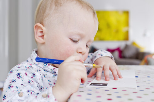 Weibliches Kleinkind zeichnet auf Papier am Tisch - CUF13288