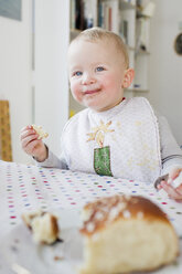 Weibliches Kleinkind isst Brot am Küchentisch - CUF13291