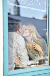 Romantisches junges Paar am Fenster eines Cafés küsst sich - CUF13361