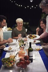 Eine Gruppe von Menschen sitzt am Tisch und genießt das Essen - ISF06211