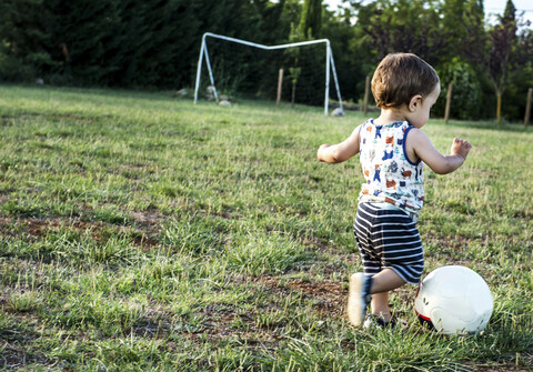 Kleinkind spielt Fußball im Park, lizenzfreies Stockfoto