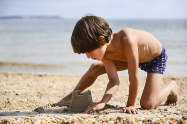 Junge baut Sandburg am Strand - ISF06235