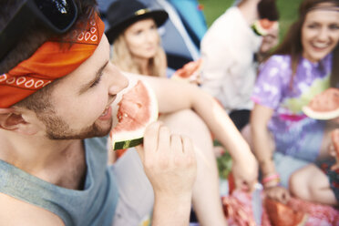 Junge erwachsene Boho-Freunde essen Melonenscheiben auf einem Festival - ISF06287