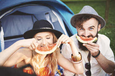 Junges Paar mit Dreispitz, das auf einem Festival einen Smiley mit einer Melonenscheibe macht - ISF06289