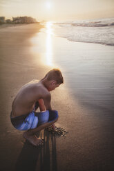 Junge zeichnet in Sand am Strand - ISF06301