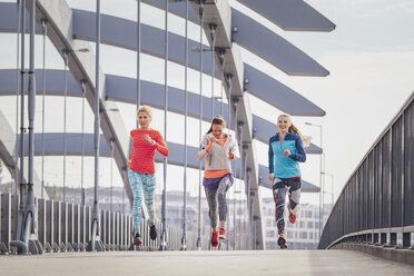 Drei Läuferinnen auf der Fußgängerbrücke der Stadt - CUF13417
