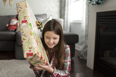 Mädchen hält Weihnachtsgeschenk lächelnd - ISF06373