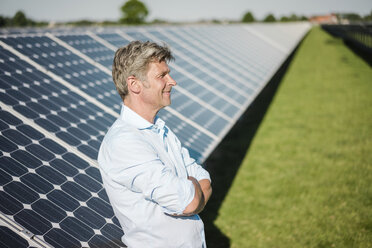 Lächelnder reifer Mann in Solaranlage stehend - MOEF01127