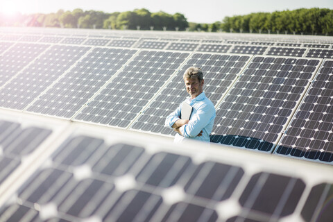 Älterer Mann mit Laptop in Solaranlage stehend, lizenzfreies Stockfoto