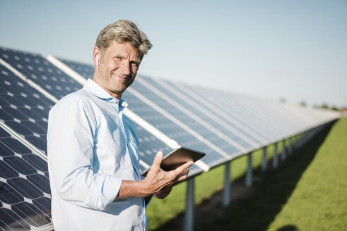 Businessman using tablet at solar park - MOEF01158