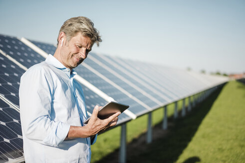 Geschäftsmann benutzt Tablet im Solarpark - MOEF01159