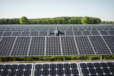 Älterer Mann steht auf einem Panel in einer Solaranlage - MOEF01175