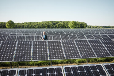 Älterer Mann steht auf einem Panel in einer Solaranlage - MOEF01176