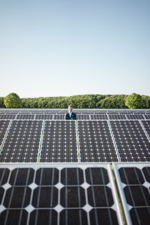 Älterer Mann steht auf einem Panel in einer Solaranlage - MOEF01178