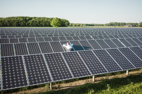 Älterer Mann, der sich auf einer Platte in einer Solaranlage ausruht - MOEF01179