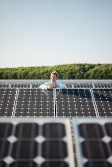 Mature man standing in solar plant - MOEF01182