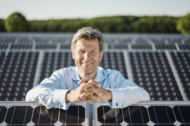 Lächelnder reifer Mann in Solaranlage stehend - MOEF01186