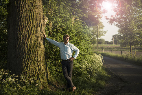 Businessman standing on tree - MOEF01201
