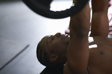 Bodybuilder hebt Langhantel auf dem Boden im Fitnessstudio - CUF13688