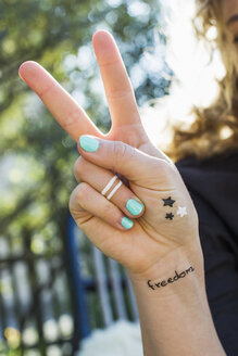 Woman making peace sign with hand - CUF13791