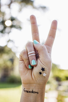 Woman making peace sign with hand - CUF13813