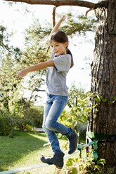 Girl balancing on rope on tree - CUF13815