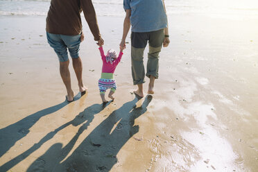 Rückenansicht eines kleinen Mädchens, das mit Vater und Großvater am Strand spazieren geht - GEMF02015