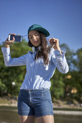 Porträt einer tanzenden jungen Frau mit Smartphone und Kopfhörern - BEF00096