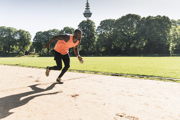 Young athlete on sports field training running - UUF13888