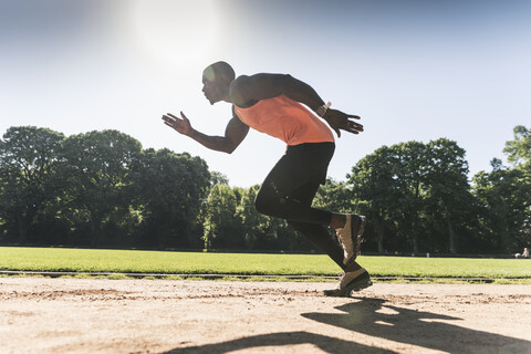 Junger Sportler auf dem Sportplatz beim Lauftraining, lizenzfreies Stockfoto