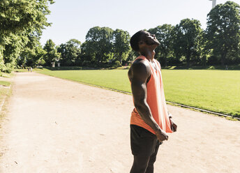 Young athlete exercising on sports field, looking up - UUF13895