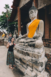 Thailand, Ayutthaya, Mutter und kleine Tochter stehen neben einer Buddha-Statue im Wat Yai Chaya Mongkhon - GEMF02026