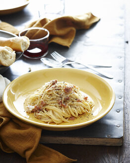 Gedeckter Tisch mit einer Schüssel Spaghetti mit Schweinebacke und Gewürzen - CUF13856