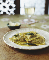 Teller mit Ravioli mit italienischem Wurstbrät, Butter, Pfeffer, Kräutern und Parmesan, Weißwein - CUF13916