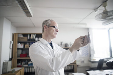 Male meteorologist examining equipment in weather station laboratory - CUF13917