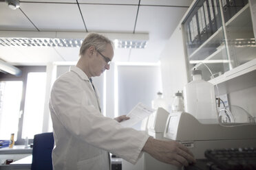 Male meteorologist reading data from weather station laboratory - CUF13920