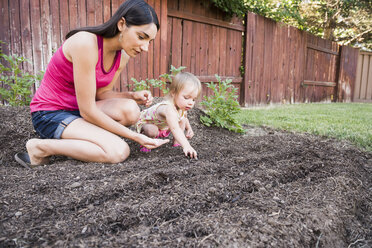 Mutter und kleine Tochter pflanzen Samen im Garten - CUF13974