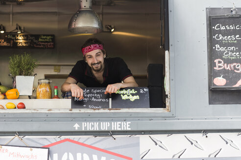 Porträt eines jungen Mannes an der Ladeluke eines Fast-Food-Wagens - CUF14005