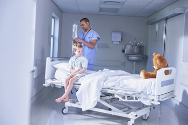 Junge Patientin sitzt auf dem Bett und starrt Teddybär in der Kinderstation des Krankenhauses an - CUF14082