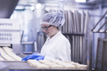 Frau bei der Arbeit in einer Fabrik für Lebensmittelproduktion - CUF14109