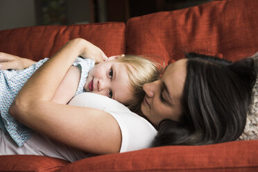 Mother hugging daughter on sofa - CUF14163