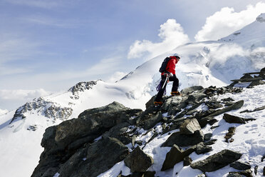 Man climbing up snow covered mountain, Saas Fee, Switzerland - CUF14195